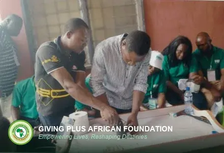 Two facilitators examining a fish closely while the class looks on