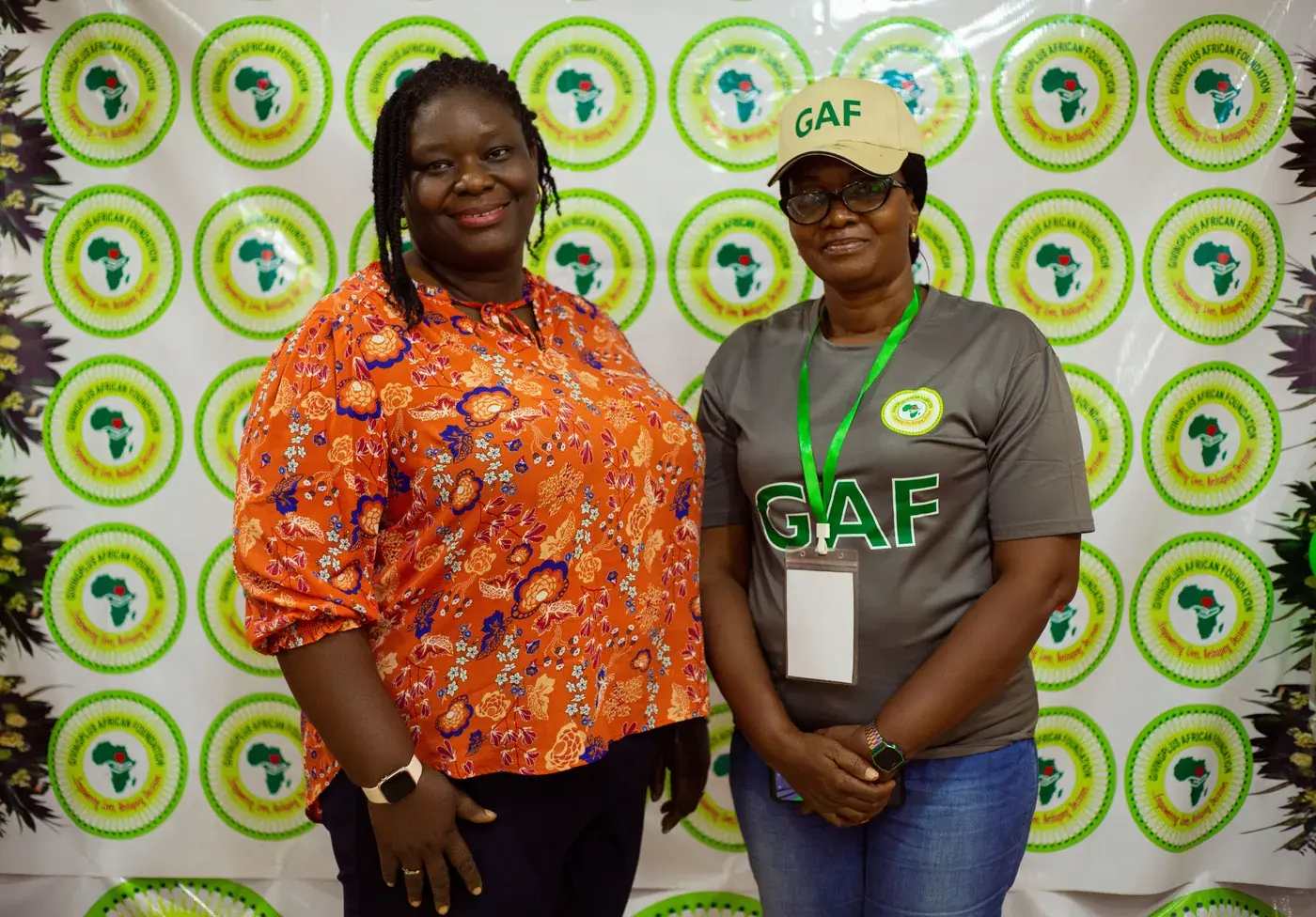 Two team members in front of the GAF backdrop