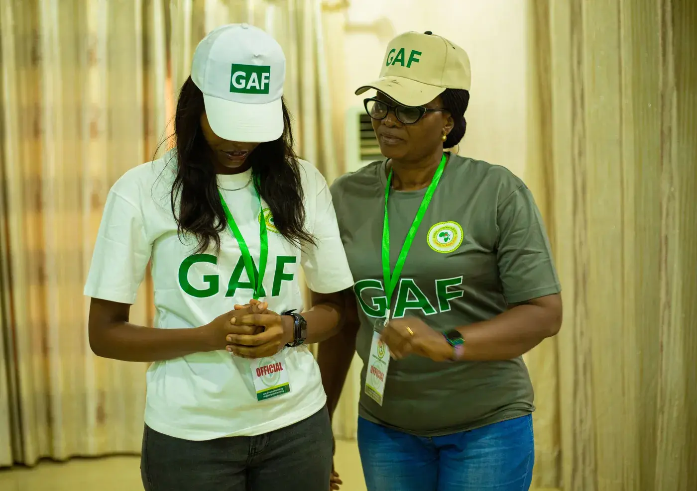 Two GAF volunteers in branded caps and shirts